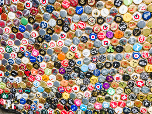 Impressive beer bottle top collection as a door liner