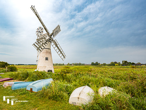 Thurne Mill with upturned rowing boats in foreground